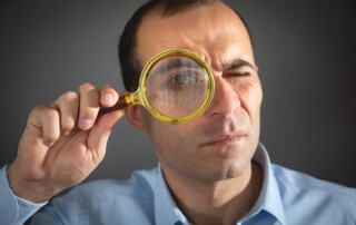 man looking through magnifying glass